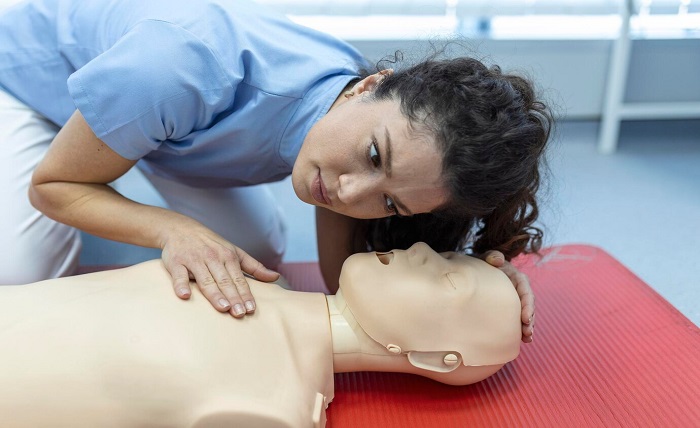Get Certified with Ease: MyCPR NOW’s Top Online CPR and First Aid Courses cpr class with instructors talking demonstrating firt aid compressions ans reanimation procedure cpr dummy 657921 335